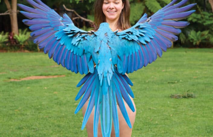 Michelle Birkett, keeper is standing with Manu, the Blue and Gold Macaw