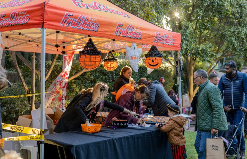 Volunteers handing out treats to guests at Boo at the Zoo