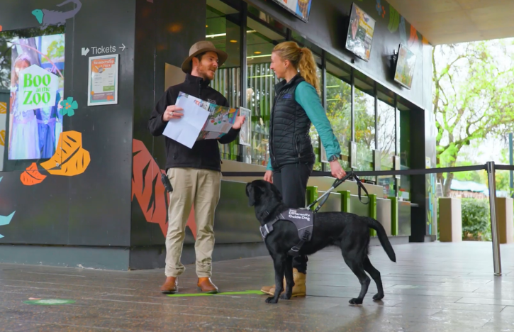 Adelaide staff member welcoming a visitor and their guide dog